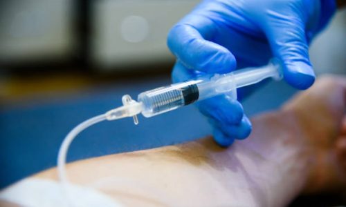 Intravenous injection clsoe up. Professional physician injects a patient.
