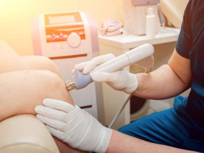 Shock wave therapy. The magnetic field, rehabilitation. Physiotherapist doctor performs surgery on a patient's knee